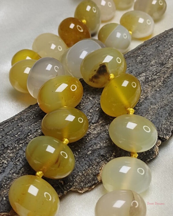 Translucent shades of ovoid-shaped lemon and citrus yellow coloured Onyx tumbles come together in this knotted 19” single strand necklace, with a strong spring-ring clasp for durability. DN 0003