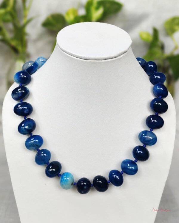 Translucent shades of ovoid-shaped deep sea blue coloured Onyx tumbles come together in this knotted 19” single strand necklace, with a strong spring-ring clasp for durability DN 0004