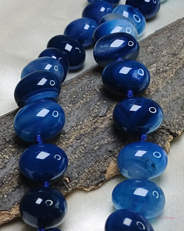 Translucent shades of ovoid-shaped deep sea blue coloured Onyx tumbles come together in this knotted 19” single strand necklace, with a strong spring-ring clasp for durability DN 0004