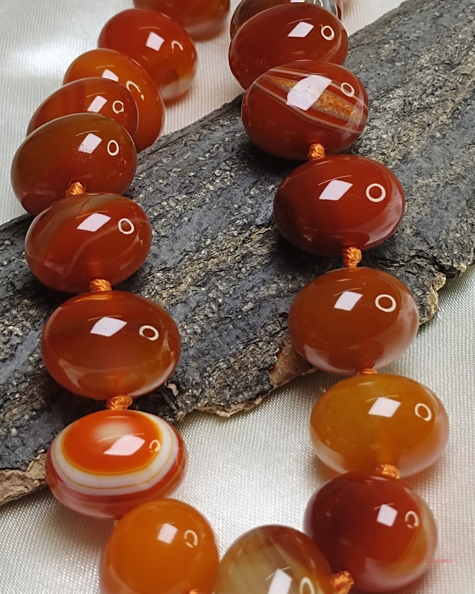 Translucent shades of ovoid-shaped toffee orange and burnt sienna coloured Onyx tumbles come together in this knotted 19” single strand necklace, with a strong spring-ring clasp for durability DN 0006