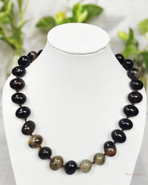 Delightfully dark shades of ovoid-shaped brownish-black coloured Onyx tumbles come together in this knotted 19” single strand necklace, with a strong spring-ring clasp for durability. DN0013