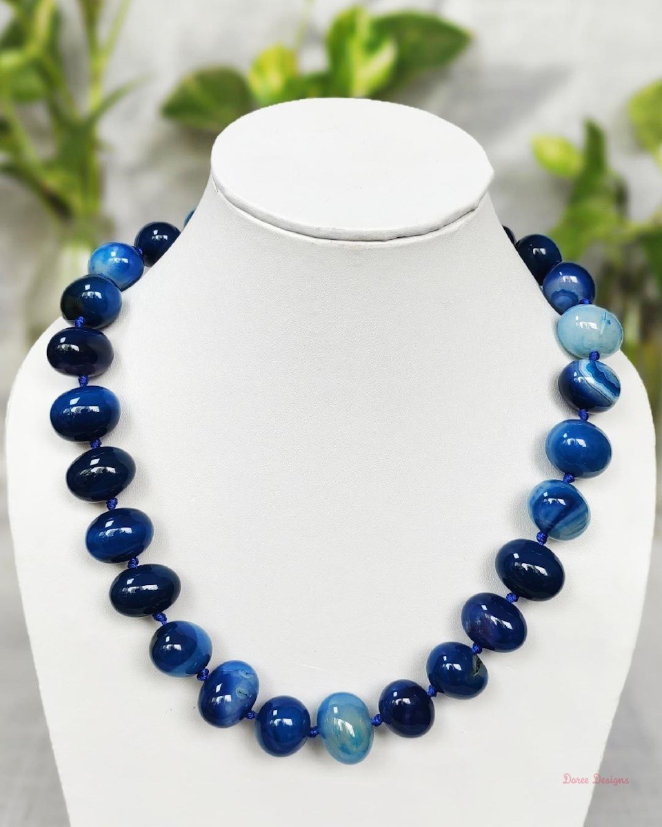 Translucent shades of ovoid-shaped deep sea blue coloured Onyx tumbles come together in this knotted 19” single strand necklace, with a strong spring-ring clasp for durability. DN0016