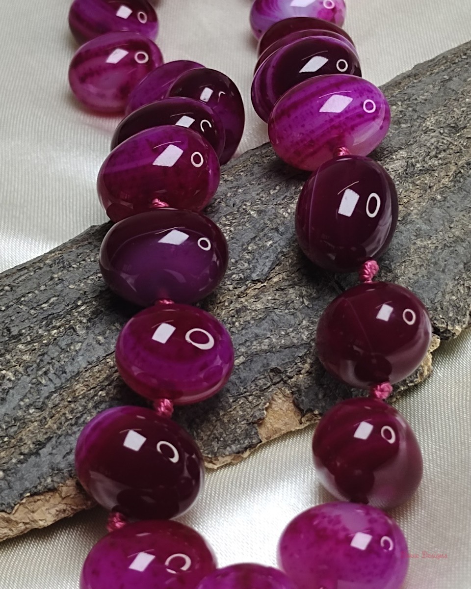 Delightfully dark shades of ovoid-shaped shocking magenta-pink coloured Onyx tumbles come together in this knotted 19” single strand necklace, with a strong spring-ring clasp for durability. DN0017