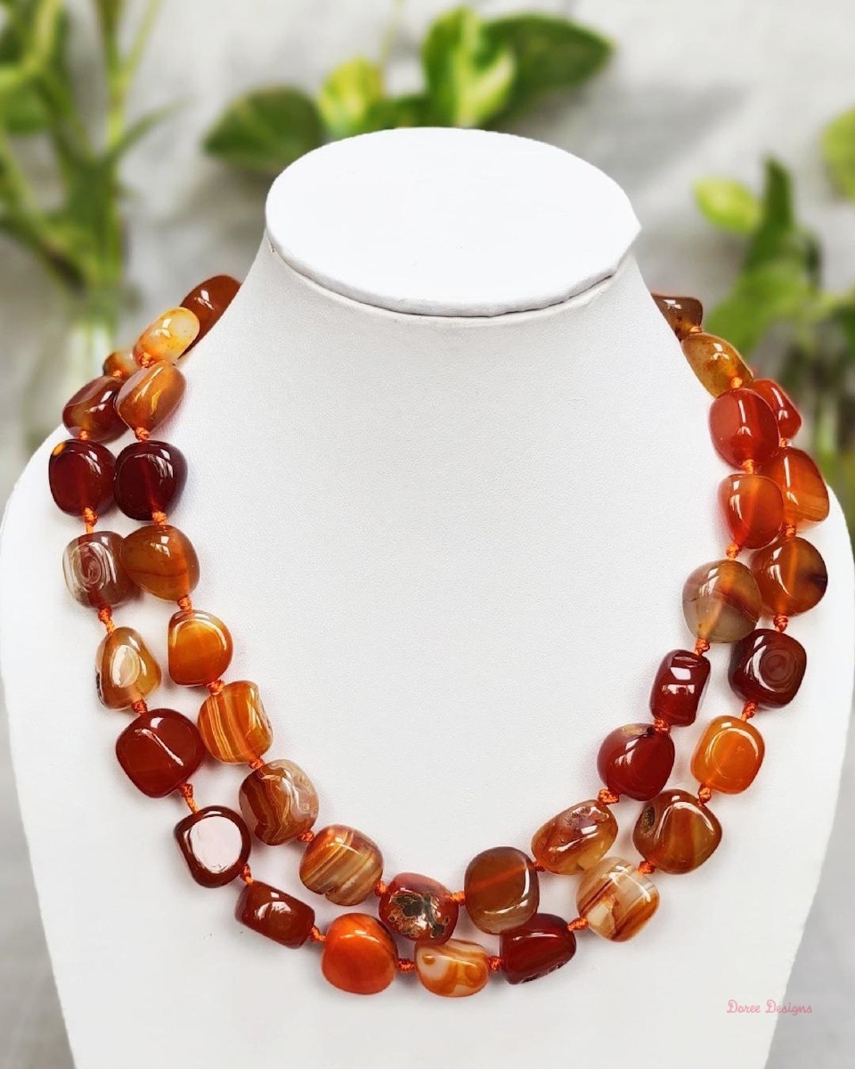 Translucent shades of ovoid-shaped toffee orange and burnt sienna coloured Onyx tumbles come together in this knotted 38” single strand necklace, with a strong spring-ring clasp for durability. DN0020